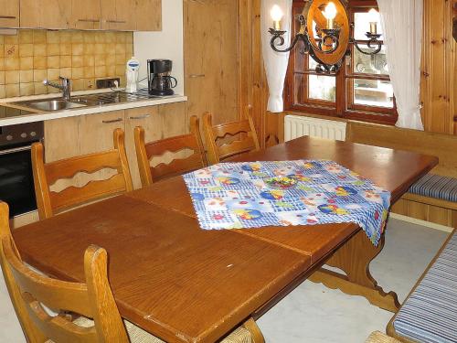 a kitchen with a wooden table with a table cloth on it at Holiday Home Jagdhaus Strengen - SNN100 by Interhome in Oberriefen