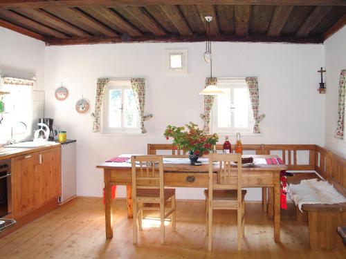 a kitchen with a wooden table and chairs in a room at Chalet Waldweber - SWG100 by Interhome in Kruckenberg