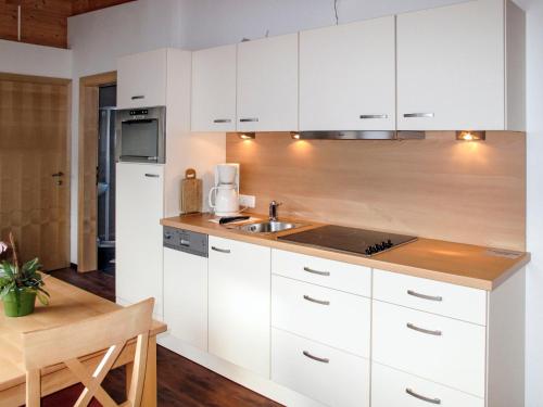 kuchnia z białymi szafkami i zlewem w obiekcie Apartment Diamant by Interhome w Solden