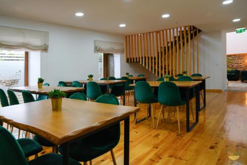 um restaurante com mesas de madeira e cadeiras verdes em PureAzibo em Macedo de Cavaleiros