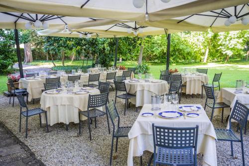 a group of tables and chairs with umbrellas at Hotel Villa La Principessa in Lucca