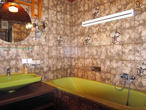 a bathroom with a green tub and a sink at Apartment Moser-1 by Interhome in Stein an der Enns