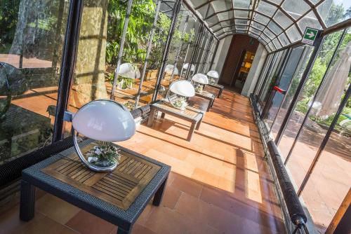 an inside view of a glass house with a table and chairs at Hotel Villa La Principessa in Lucca