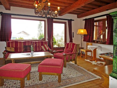 uma sala de estar com cadeiras vermelhas e uma mesa em Holiday Home Walcher - RMU220 by Interhome em Ramsau am Dachstein