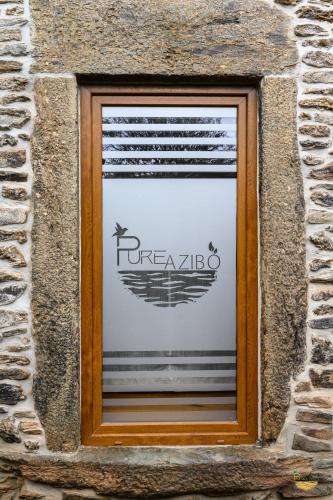 a window in a stone building with a toraja sign at PureAzibo in Macedo de Cavaleiros