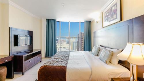 a hotel room with a large bed and a television at City Stay Residences - Serviced Apartments Al Barsha in Dubai