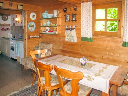 a kitchen with a wooden table and a table and chairs at Holiday Home Kunzhof - TFN110 by Interhome in Winklern