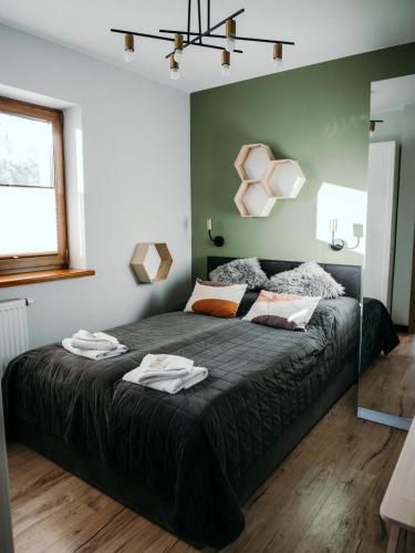 a bedroom with a large bed with two towels on it at Willa Pachówka - tam, gdzie natura spotyka się z nowoczesnością in Bukowina Tatrzańska