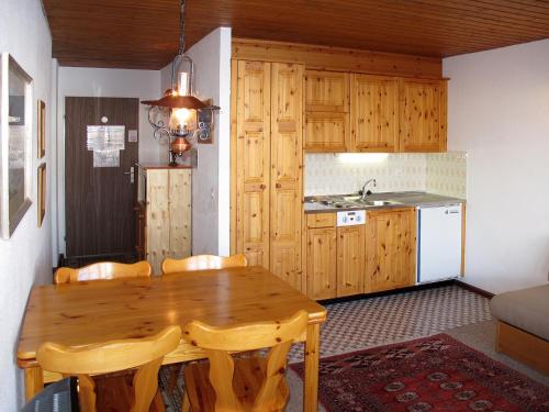 cocina con mesa de madera con sillas y fregadero en Apartment Résidence Dixence-15 by Interhome, en Les Collons