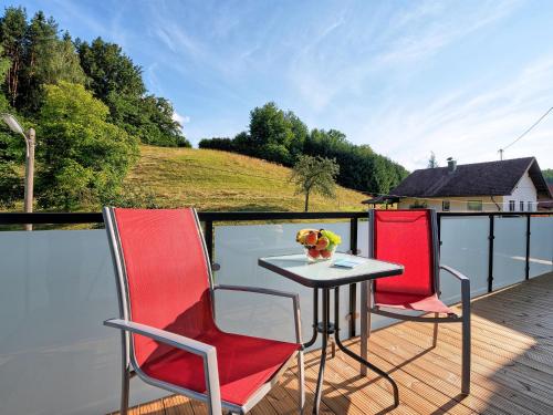een terras met twee stoelen en een tafel op het water bij Apartment Deutschbauer - FAK100 by Interhome in Egg am Faaker See