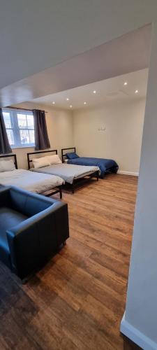 a room with three beds and a couch in it at Market Place guest house in Burslem