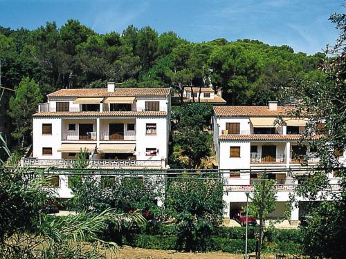 een groot wit gebouw op een heuvel met bomen bij Apartment S'Esquirols I by Interhome in Begur