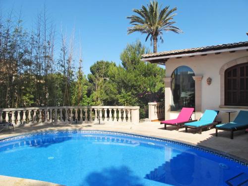 a swimming pool with two chairs and a house at Holiday Home Villa Munar I - CRJ152 by Interhome in Cala Ratjada