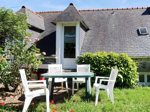 three chairs and a table in a yard at Holiday Home Les Blés by Interhome in Plozévet