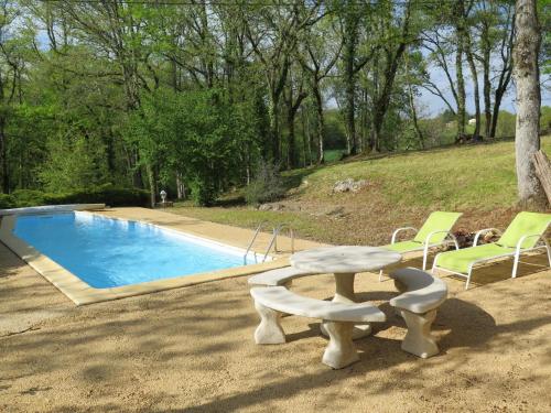 a swimming pool with a table and chairs next to it at Holiday Home Le Chêne by Interhome in Blanquefort-sur-Briolance