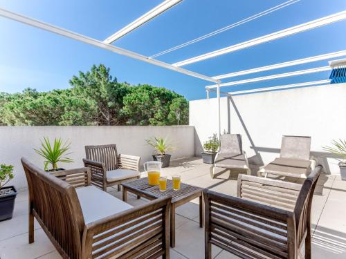 d'une terrasse avec des chaises et une table avec du jus d'orange. dans l'établissement Apartment Les Pins Parasols-2 by Interhome, à Argelès-sur-Mer