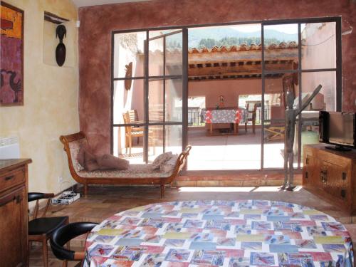 a living room with a large window and a bed at Holiday Home Les Arcades by Interhome in Nyons