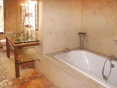 a bathroom with a tub and a table and a sink at Holiday Home Les Arcades by Interhome in Nyons