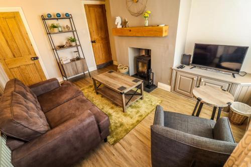 a living room with a couch and a fireplace at Cottages in Derbyshire - Riverside Cottage in Duffield