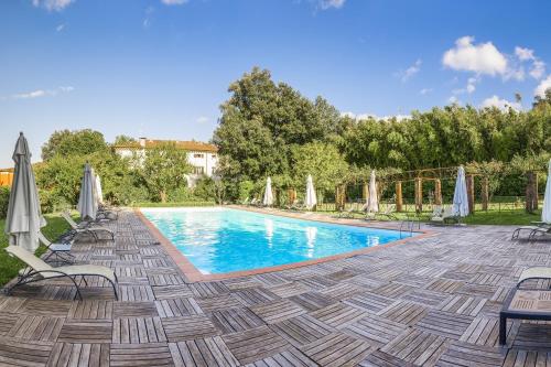 a swimming pool with chairs and umbrellas on a patio at Hotel Villa La Principessa in Lucca