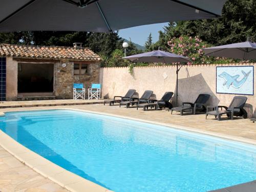 une piscine avec chaises et parasols à côté d'un bâtiment dans l'établissement Holiday Home Mas du Combaud-2 by Interhome, à Roquebrune-sur Argens