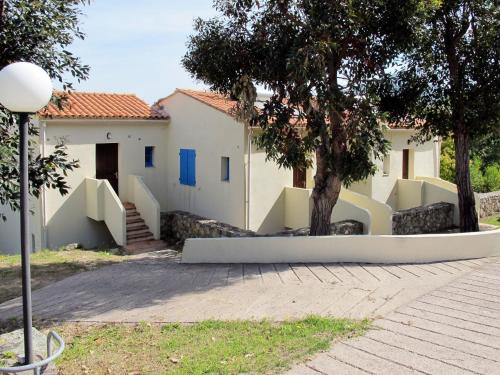 une maison avec un arbre en face dans l'établissement Apartment Cala di Sole - ALG131 by Interhome, à Algajola