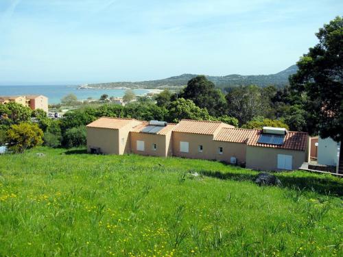 une rangée de maisons dans un champ d'herbe dans l'établissement Apartment Cala di Sole - ALG131 by Interhome, à Algajola