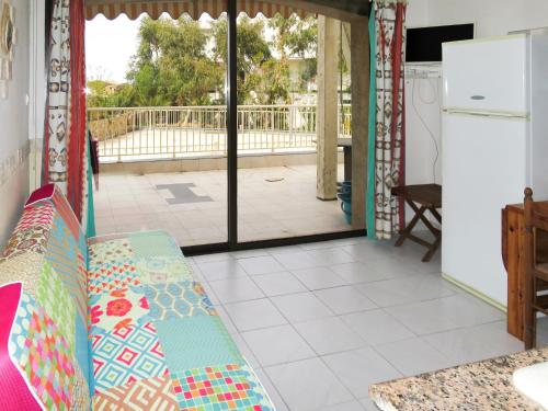 un soggiorno con un divano e una porta scorrevole in vetro di Apartment Résidence Posidonie Hollywood by Interhome a LʼÎle-Rousse