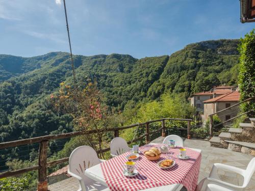 een tafel en stoelen op een balkon met uitzicht op de bergen bij Holiday Home Da Franca by Interhome in Stazzema