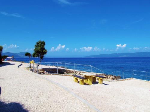 a bench on a beach next to the water at Apartment Ulika by Interhome in Ravni