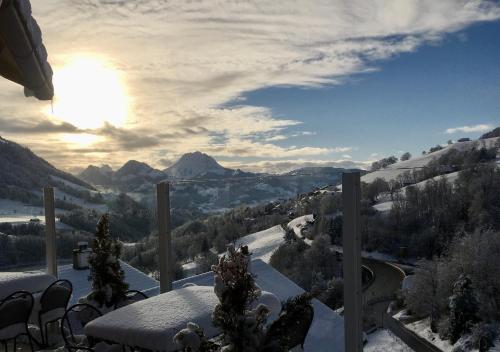 - Balcón cubierto de nieve con vistas a la montaña en Chalet les Ecureuils Apartment Penthouse Suite, en Crésuz
