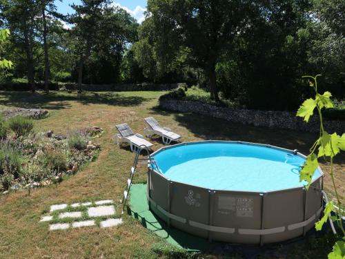a swimming pool in a yard with two chairs at Holiday Home Nino - LBN305 by Interhome in Kršan