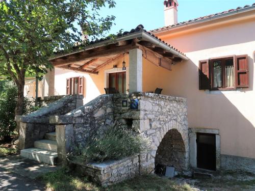 a house with a stone wall and a stone oven at Holiday Home Nino - LBN305 by Interhome in Kršan