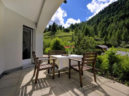 a table and chairs on a patio with a view at Apartment Chesa Flora 53 by Interhome in St. Moritz