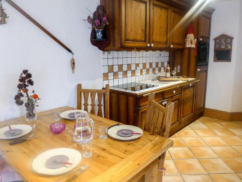 Apartment Le Krystor by Interhome في شامونيه مون بلان: مطبخ مع طاولة خشبية عليها لوحات