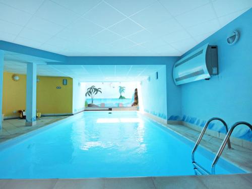 a swimming pool in a building with a blue ceiling at Villa Lenno by Interhome in Lenno