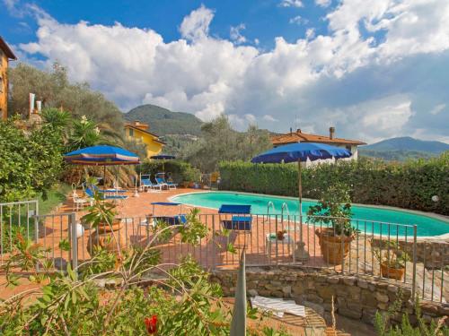 un complejo con una piscina con sombrillas en Holiday Home Bruna by Interhome, en Massarosa