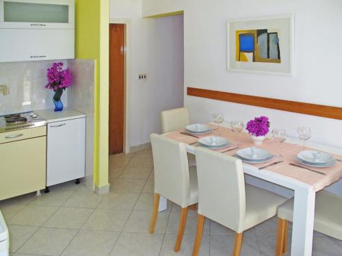 eine Küche und ein Esszimmer mit einem Tisch und Stühlen in der Unterkunft Apartment Palma - RAC108 by Interhome in Rabac