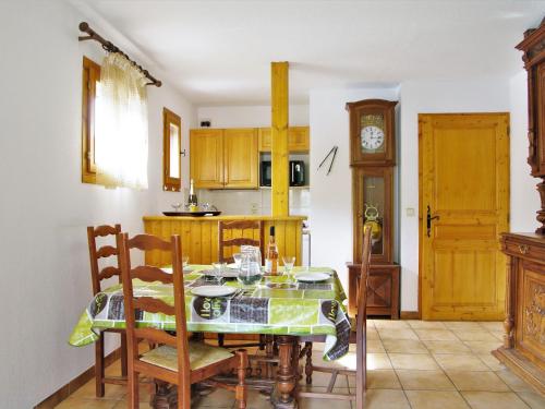 une cuisine avec une table, des chaises et une horloge dans l'établissement Apartment L'Hermine by Interhome, aux Houches