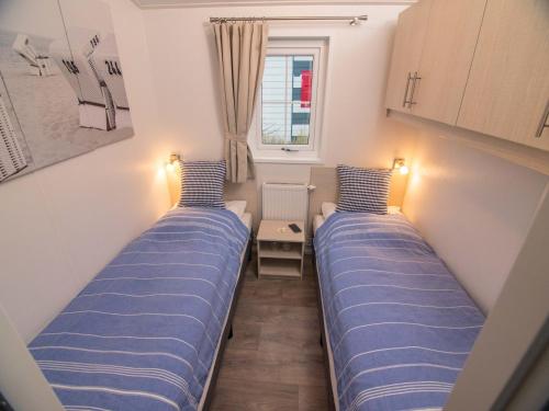 Duas camas num pequeno quarto com uma janela em Pier98 28 em Scharbeutz