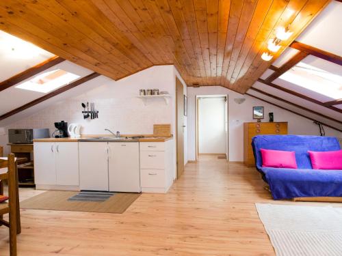 eine Küche mit weißen Schränken und einer blauen Couch in der Unterkunft Apartment Teodora-2 by Interhome in Lovran