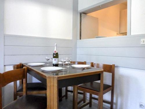una sala da pranzo con tavolo e bottiglia di vino di Apartment Le Chamois Blanc-3 by Interhome a Chamonix-Mont-Blanc