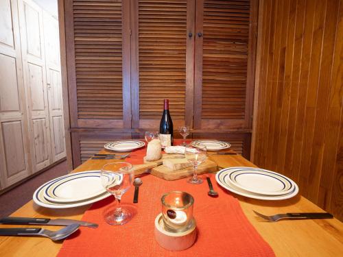 - une table avec des assiettes, des verres et une bouteille de vin dans l'établissement Apartment Le Grand Tichot A et B - Val Claret-12 by Interhome, à Tignes