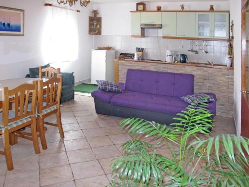 a living room with a purple couch and a kitchen at Holiday Home Vesna by Interhome in Diklo