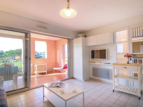 a living room with a table and a kitchen at Apartment Les Marines-21 by Interhome in La Foux