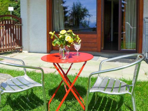 ヴェルビエにあるApartment Pigne 1 by Interhomeの赤いテーブルと花瓶、椅子2脚
