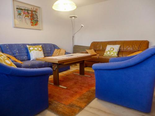 een woonkamer met twee blauwe banken en een houten tafel bij Apartment Viscaria-1 by Interhome in Zermatt