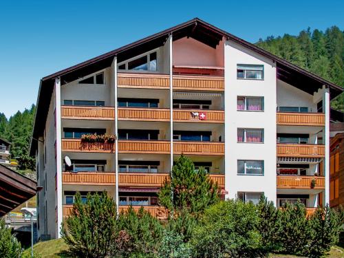 un edificio de apartamentos con balcones y árboles en Apartment Beaulieu-2 by Interhome, en Zermatt