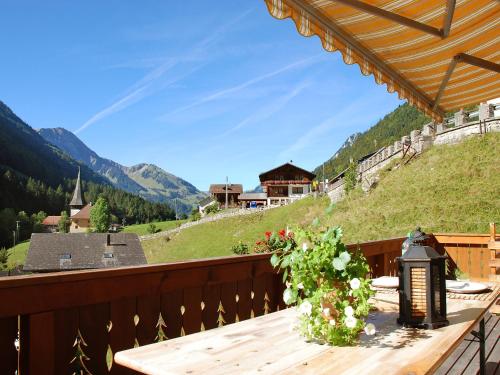 una mesa de madera en un balcón con vistas a la montaña en Chalet Höfli by Interhome en Jaun