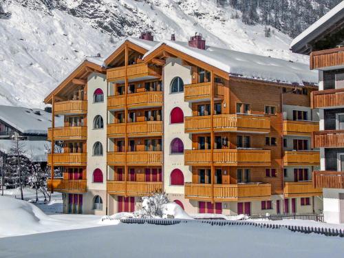 a large building with wooden balconies in the snow at Apartment Breithorn by Interhome in Zermatt